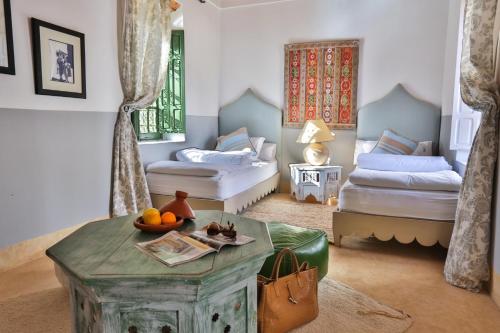 a room with two beds and a table with fruit on it at Les Jardins de Villa Maroc in Essaouira