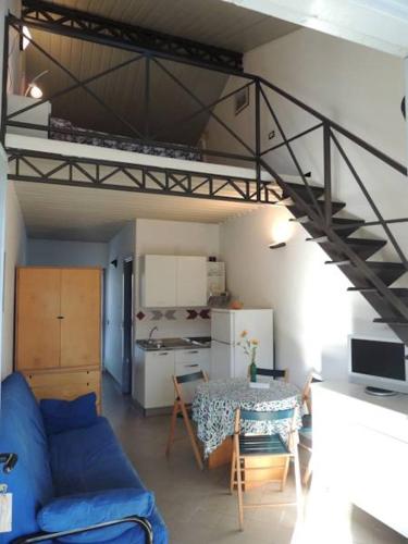 a living room with a blue couch and a kitchen at Appartamenti Villaggio Internazionale in Albenga