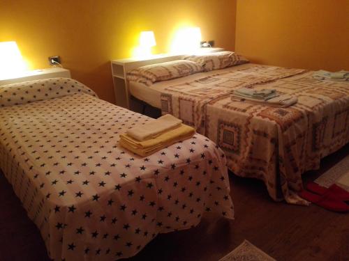 a hotel room with two beds and a table at B&B Villa Claudia in Lavena Ponte Tresa