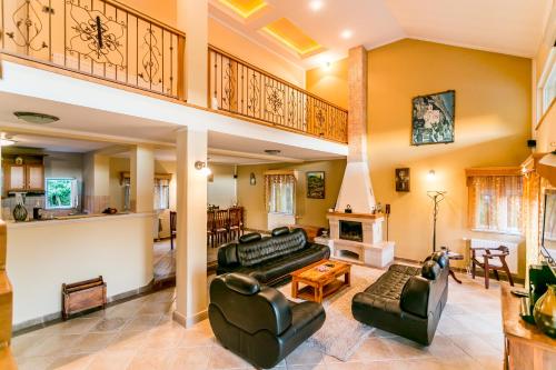 una gran sala de estar con sofás y una escalera. en Villa Besha, en Herceg-Novi