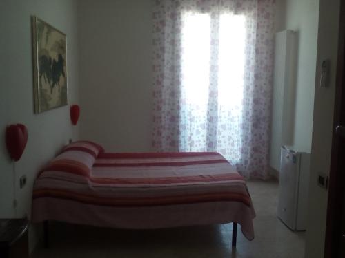 a bed in a room with a window with a blanket at Sister's love in Matera