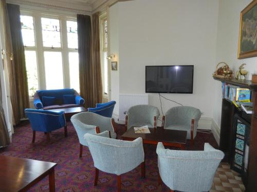 a living room with chairs and a table and a tv at Morangie Hotel Tain in Tain