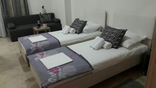 2 Betten in einem kleinen Zimmer mit Sofa in der Unterkunft Apartment Smodlaka in Dugopolje