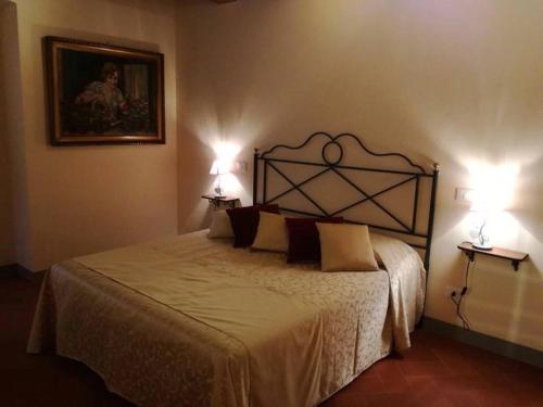 a bedroom with a large bed with two lamps at Relais Villa Poschi in Pugnano