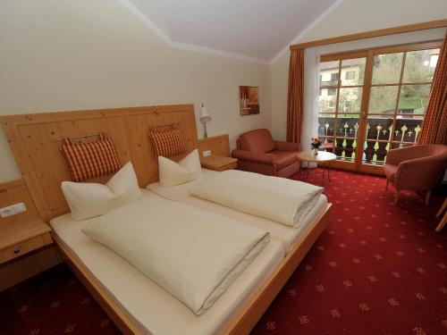 ein Schlafzimmer mit einem großen weißen Bett und einem Fenster in der Unterkunft Landgasthof Drei Rosen in Bernried