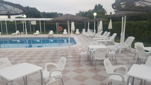 a group of tables and chairs next to a pool at Hotel Torre De Los Guzmanes in La Algaba