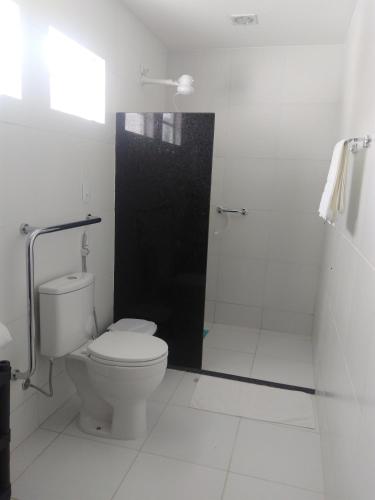 a white bathroom with a toilet and a shower at Casa Schneider in Gravatá