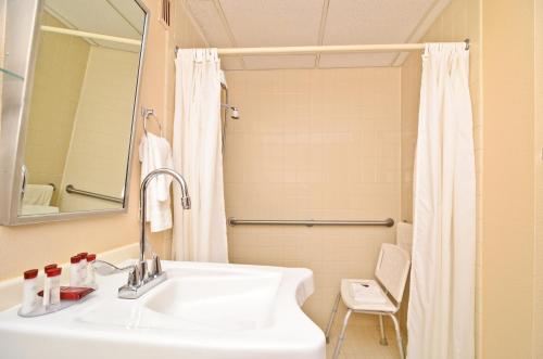 Baño blanco con lavabo y espejo en Pocono Resort & Conference Center - Pocono Mountains, en Lake Harmony