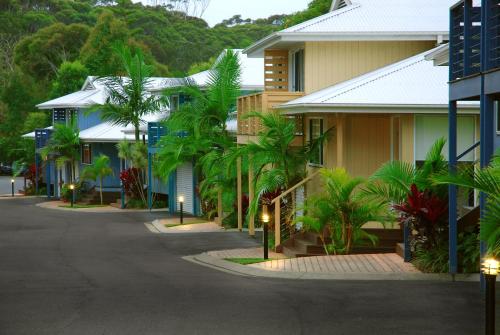 a street with buildings and palm trees and lights at Flynns on Surf Beach Villas in Port Macquarie