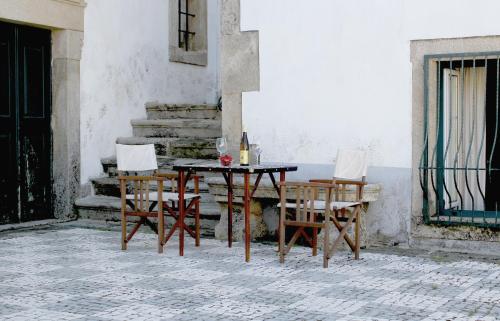 a table and chairs sitting next to a building at Solar da Roseira in Capinha