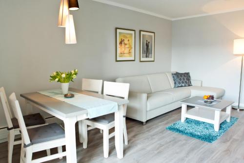 een woonkamer met een witte tafel en een bank bij Ferienwohnung Meeresrausch in Westerland