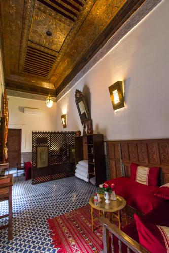 a living room with a red couch and a table at Riad Al Makan Fes & Spa in Fès