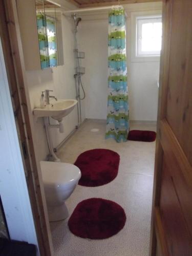 ハーグフォシュにあるStuga Hultのバスルーム(洗面台、トイレ、赤いラグ付)