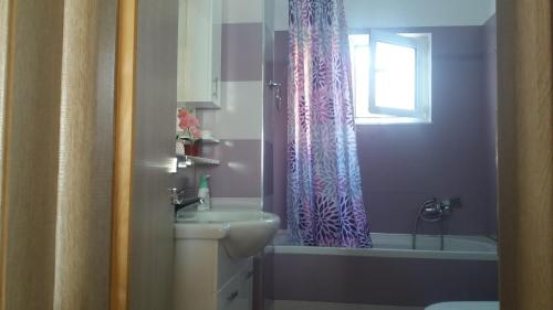 a bathroom with a sink and a shower curtain at Anna Apartments in Sarandë