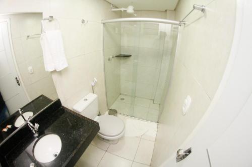 a bathroom with a shower and a toilet and a sink at LW Hotel in Arcoverde