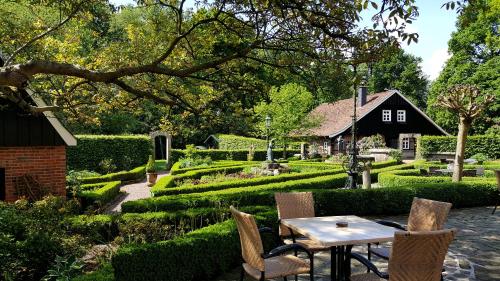 einen Garten mit Tisch und Stühlen und ein Haus in der Unterkunft FeWo Grafschaft in Nordhorn