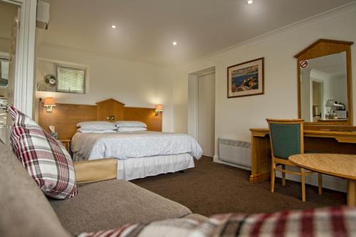 um quarto de hotel com uma cama e uma secretária em Annexe at Gosfield Lake em Gosfield