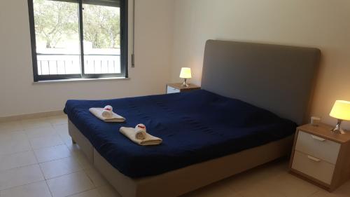 um quarto com uma cama com dois pares de chinelos em Vista das Ondas Apartment em Albufeira