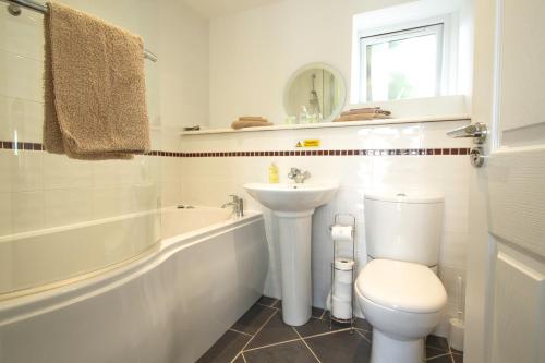 a bathroom with a sink and a toilet and a bath tub at Annexe at Gosfield Lake in Gosfield