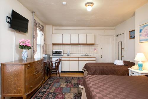 a small room with two beds and a kitchen at The Farrington Inn in Boston