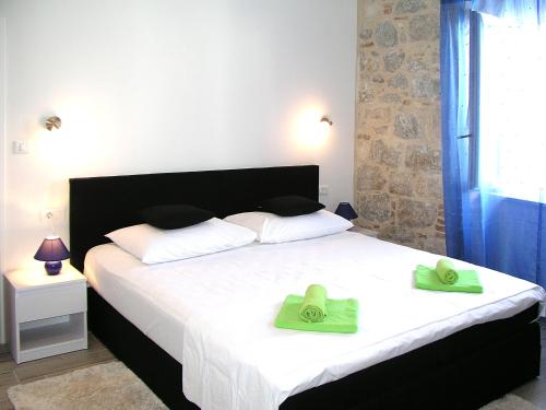 een slaapkamer met een bed met twee groene handdoeken erop bij Apartmani KLARA i GRACIA in Split