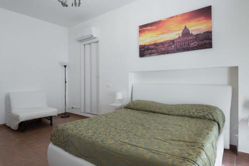 ローマにあるCornelia Penthouseのベッドルーム1室(ベッド1台付)が備わります。壁に絵が飾られています。