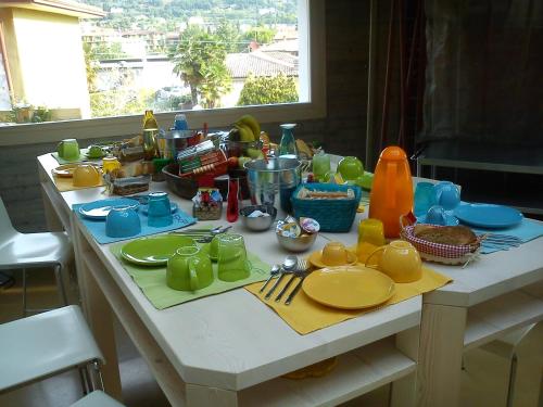 einen Tisch mit Tellern und Küchenutensilien darauf in der Unterkunft Bikapi in Garda
