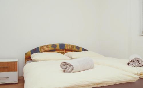 a bedroom with a white bed with towels on it at Apartmani Balibeg in Sarajevo