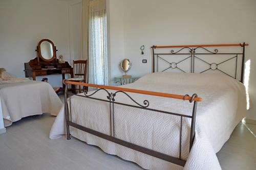 a bedroom with a bed and a mirror and a table at B&B Cara'a mare in Santa Maria Navarrese