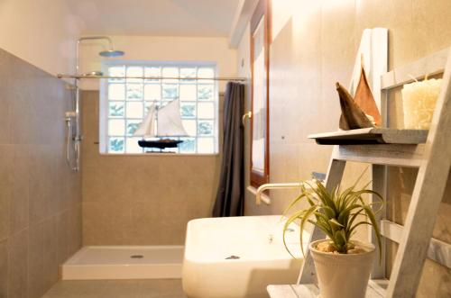 baño con lavabo, ducha y ventana en B&B Cara'a mare, en Santa Maria Navarrese
