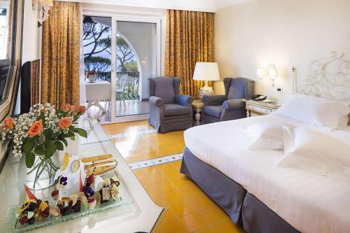 a hotel room with a bed and a table with flowers at Excelsior Belvedere Hotel & Spa in Ischia