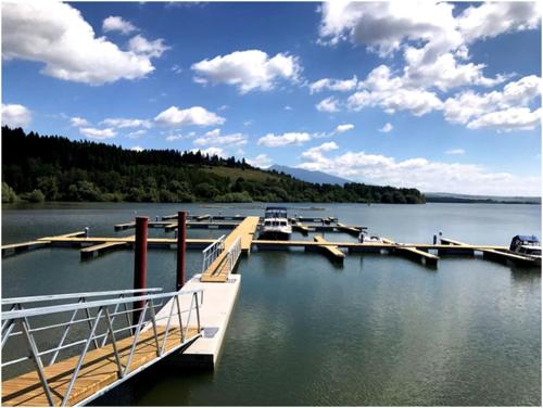 a dock with boats in the water on a lake at Chata Alexandra in Bobrovník