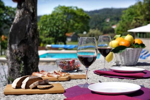 a table with two glasses of wine and bread and fruit at Casa da Torre in Pico