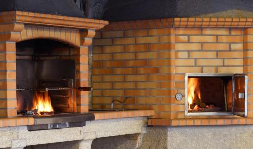 a brick oven with fire inside of it at Casa da Torre in Pico