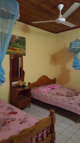 a bedroom with two beds and a mirror and a ceiling at Isuruma Rest in Kataragama