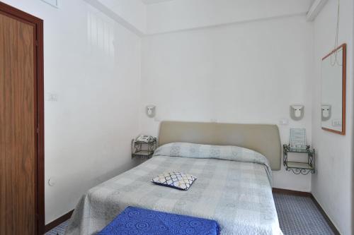 a small bedroom with a bed with a blue blanket at Hotel Europa in Minori