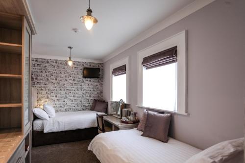 - une chambre avec 2 lits, un bureau et une fenêtre dans l'établissement Anvershiel House, à Portrush