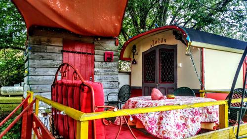a table and chairs in front of a house at La Roulotte De Lola - Chambre d'hôtes in La Celle