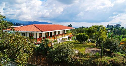 a house with an orange roof on a hill at Hostal Casa de Los Taitas in Salento