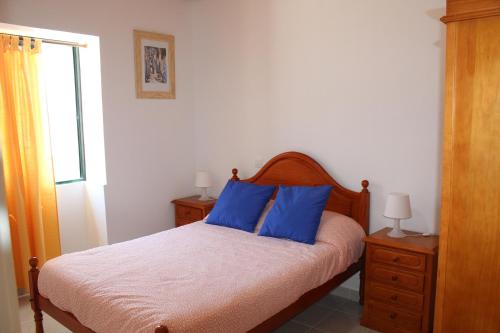 ポルト・サントにあるCasa da Ribeiraのベッドルーム1室(青い枕2つ付きのベッド1台付)
