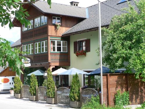 a building with chairs and umbrellas in front of it at Kalßwirt in Bad Aussee