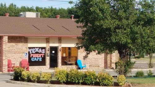 a brick building with a blue chair in front of it at Shiloh Inn Lamesa in Lamesa