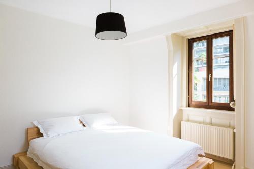 a bedroom with a white bed and a window at Montreux Apartment on the Lake in Montreux