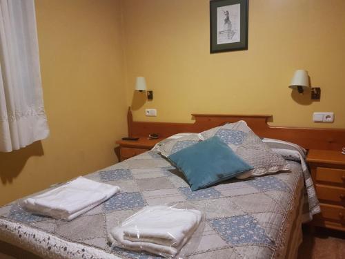 a bedroom with a bed with two towels on it at Hostal los nogales in Cangas del Narcea