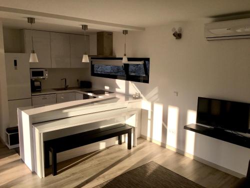 a living room with a fireplace and a kitchen at The Green Roof House in Vieira do Minho