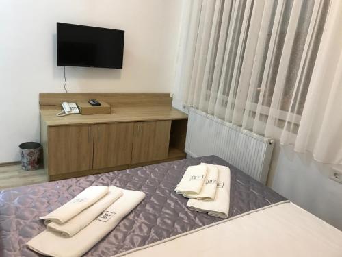 a hotel room with a bed with two towels on it at Villa Nina Hotel & Lounge bar in Skopje