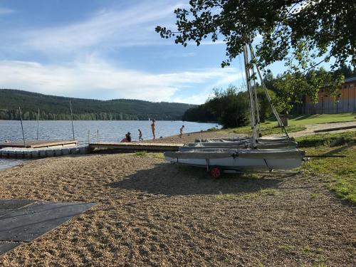 a boat parked on the shore of a lake at Apartmány Pinie Lipno in Lipno nad Vltavou