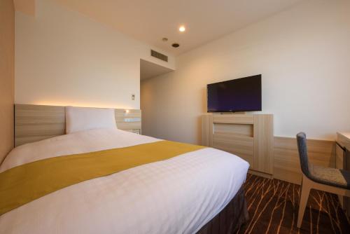 a hotel room with a bed and a flat screen tv at Hotel JAL City Sendai in Sendai