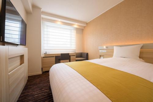 a hotel room with a bed and a desk at Hotel JAL City Sendai in Sendai