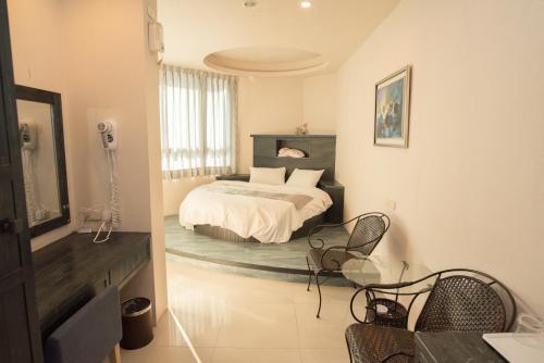 1 dormitorio con 1 cama, mesa y sillas en Long Hong, en Magong